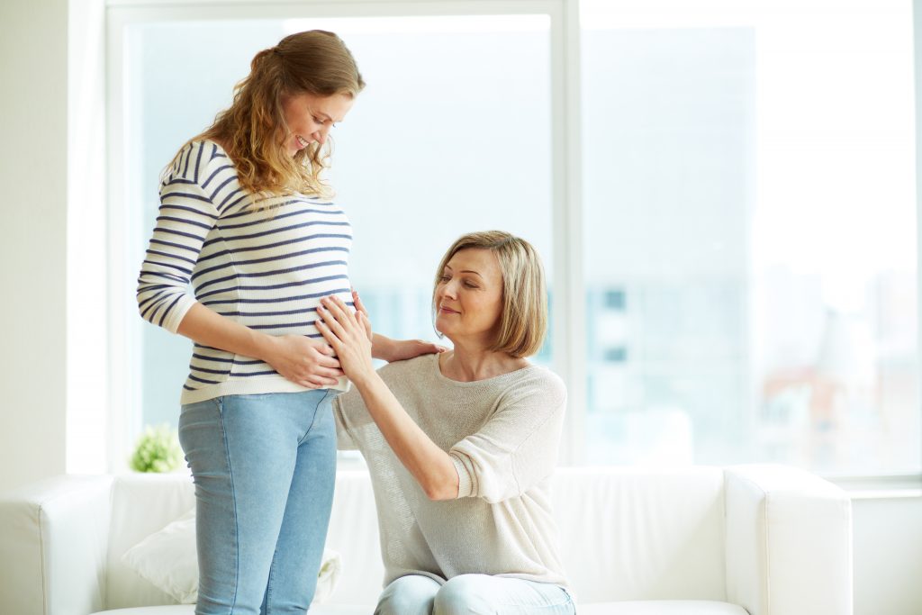 mulher grávida recebendo carinho da mãe